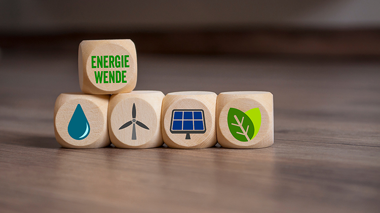 Mehrere Holzw&uuml;rfel nebeneinander positioniert mit Symbolen zum Thema Nachhaltigkeit, oben auf ein weitere Holzw&uuml;rfel mit dem Schriftzug Energiewende