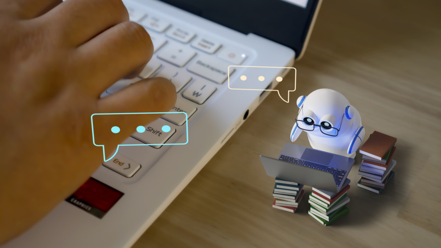 Nahaufnahme der rechten Hälfte eines Laptops, auf der die rechte Hand einer Person ist. Neben dem Laptop ist ein sehr kleiner, weißer Roboter, vor dem auf zwei Bücherstapeln ein aufgeklappter Laptop ist. Über dem Roboter ist eine Sprechblase.
