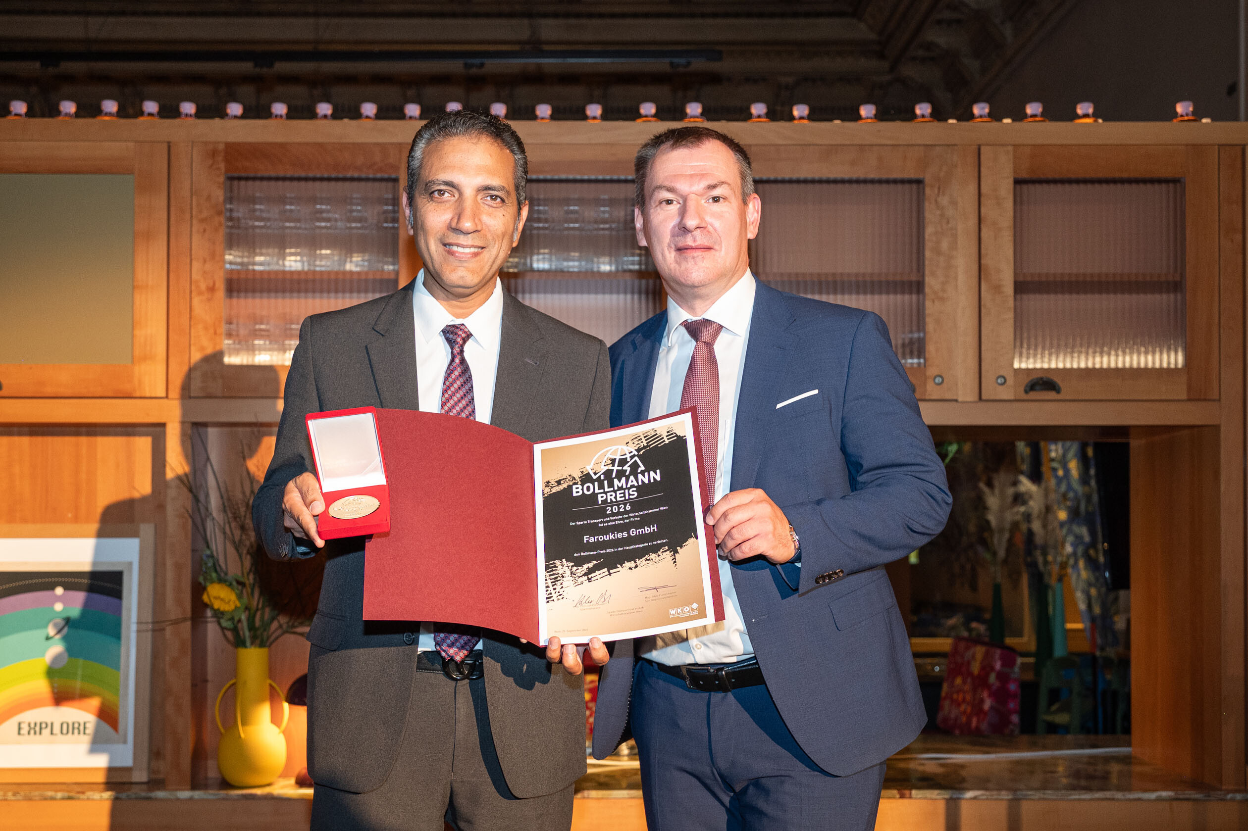 Der Gewinner des Bollmann-Preises 2026, Aiman Attia, Inhaber der Taxischule EasyCab (Faroukies GmbH), und Christian Holzhauser, Obmann der Sparte Transport und Verkehr in der Wirtschaftskammer Wien. 