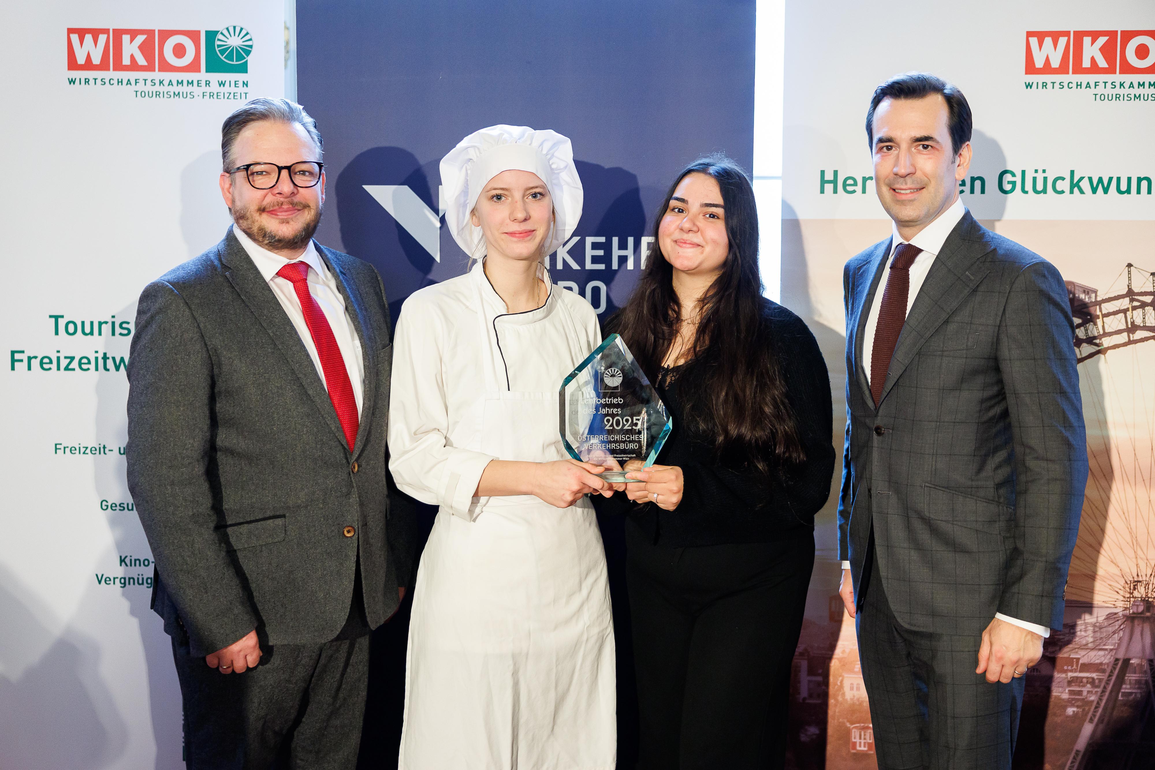 Dominic Schmid (l.) zeichnete Verkehrsbüro-CEO Martin Winkler aus. Mit dabei zwei der aktuell mehr als 100 Lehrlinge: Clara Kühnel (2.v.l., Konditorin) und Mariola Tairovic (Reisebüro). 