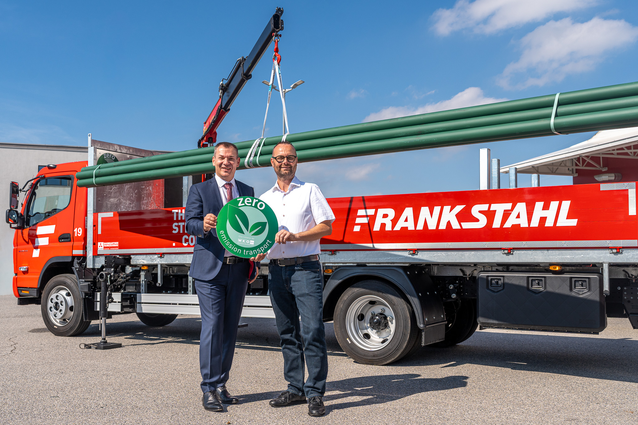 Christian Holzhauser, Obmann der Sparte Transport und Verkehr in der Wirschaftskammer Wien, und Roman Divoky, Logistikleiter bei Frankstahl, mit dem vollelektrischen Lkw und seinem