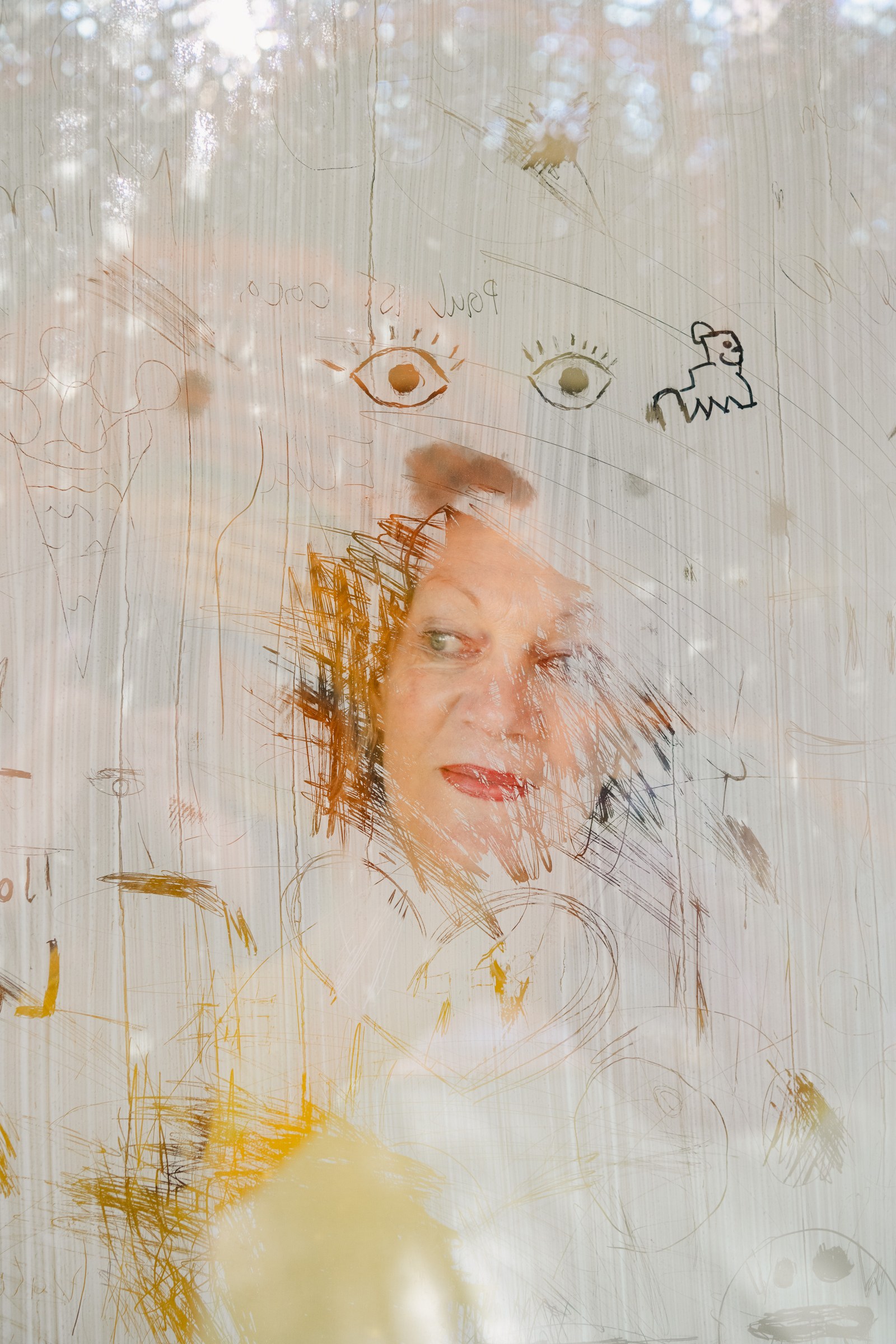 Mona Jas, K&uuml;nstlerische Direktorin des Kinder Kunst Labors in Sankt P&ouml;lten fotografiert durch ein Fenster auf dem getrocknete Buttermilch die Unterlage f&uuml;r Kinderzeichnungen bietet