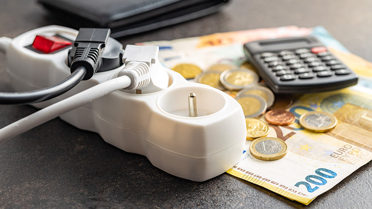 Verteilerstecker, Eurom&uuml;nzen und Scheine sowie Taschenrechner auf Tisch liegend