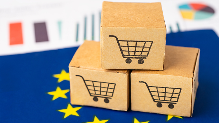 Kleine Pakete mit aufgedruckten Symbolen von Einkaufsw&auml;gen, platziert auf blauem Untergrund mit gelben Sternen