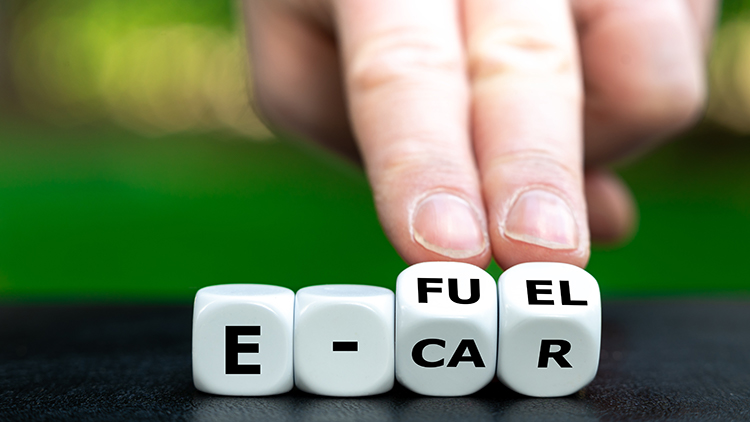 Hand W&uuml;rfel drehend mit der Aufschrift e-car und e-fuel